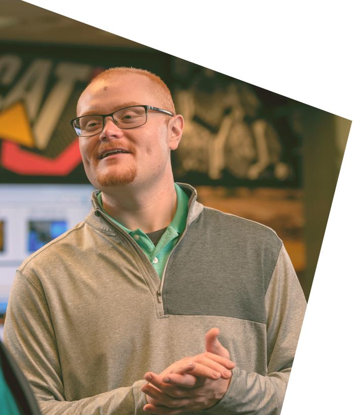 眼鏡をかけ、グレーのセーターを着た人