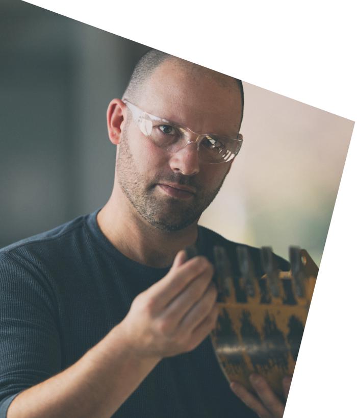 戴着安全眼镜的人拿着一块金属