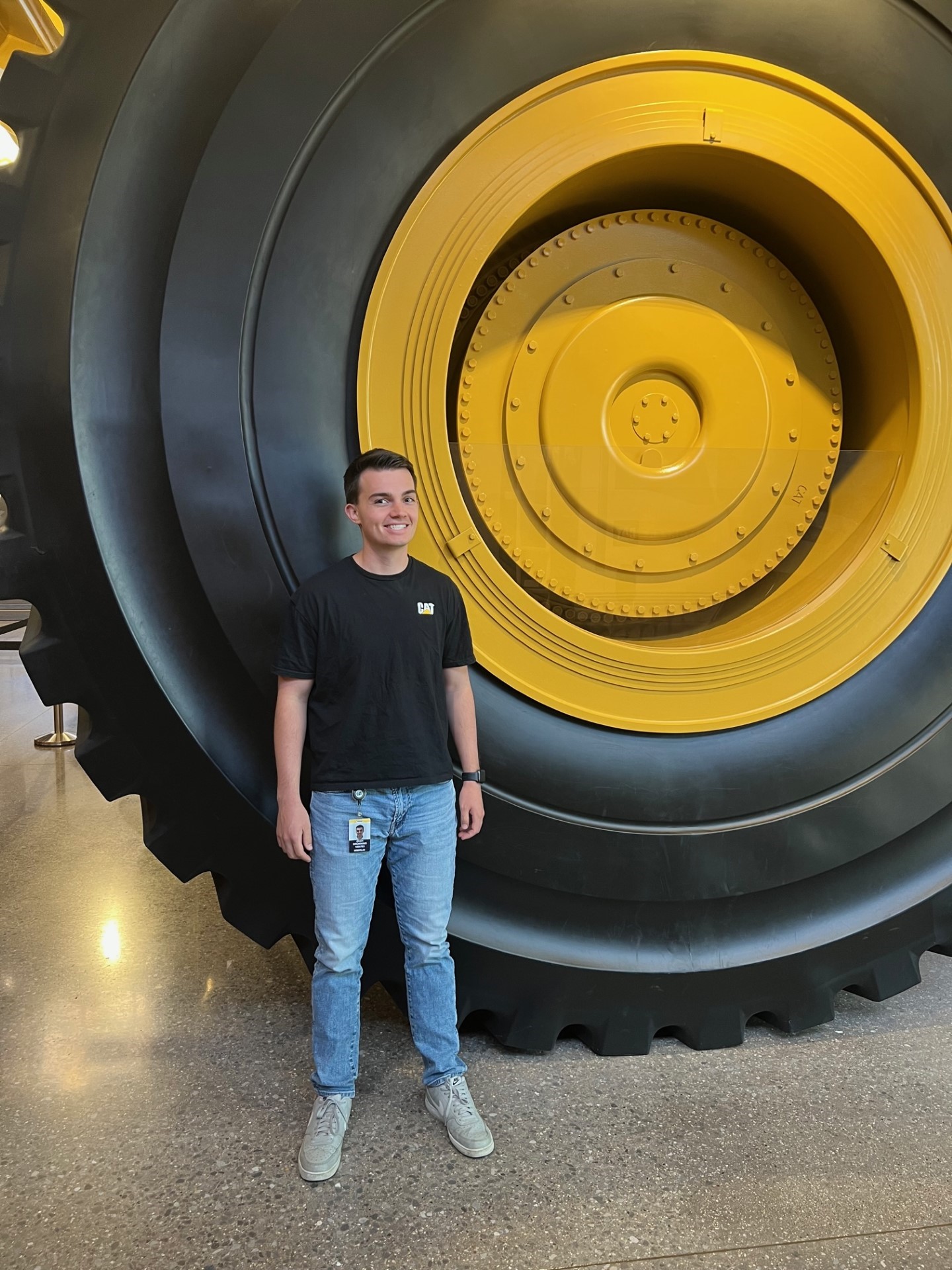 a person standing in front of a large tire