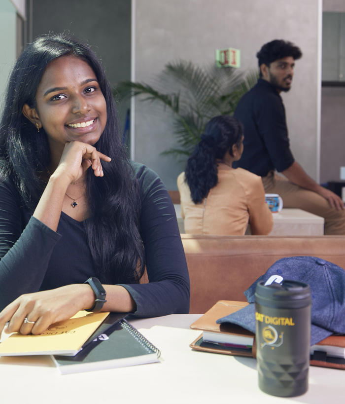 a person sitting at a table with her hand on her chin