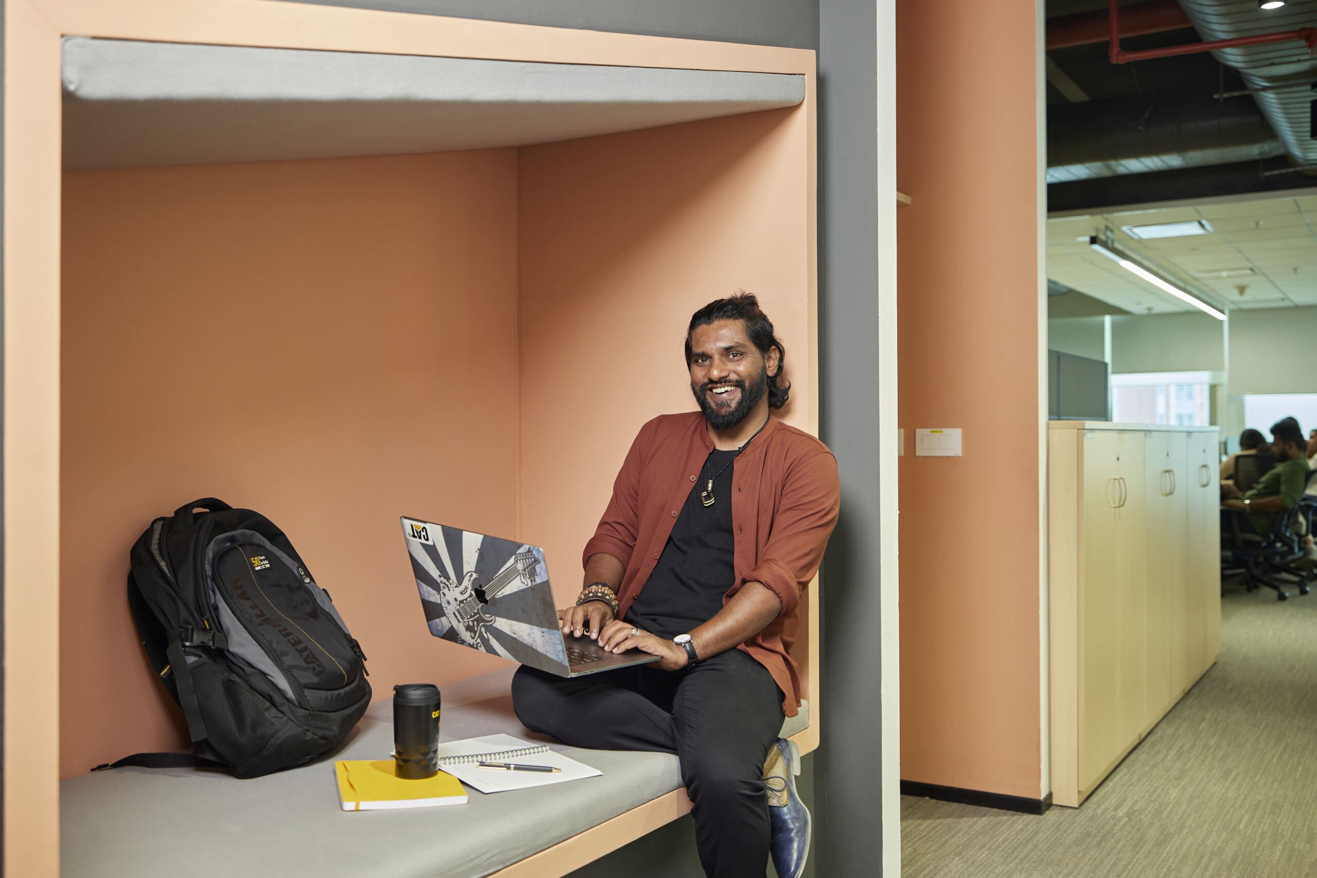 坐在床上使用笔记本电脑的人