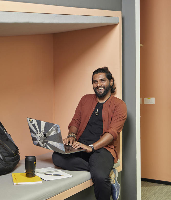 坐在床上使用笔记本电脑的人