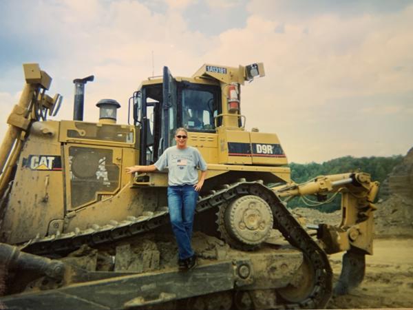 커다란 노란색 트랙터 위에 서 있는 사람