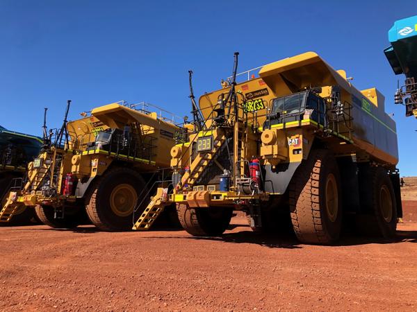 未舗装の道路に駐車された黄色いトラックのグループ