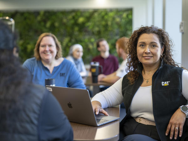 a person sitting at a table with a laptop