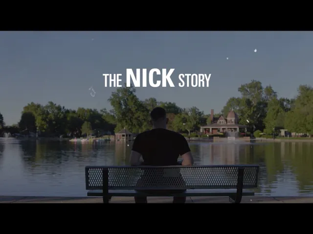 a person sitting on a bench looking at a body of water