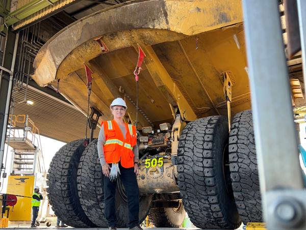 a person in a hard hat standing in front of a large truck