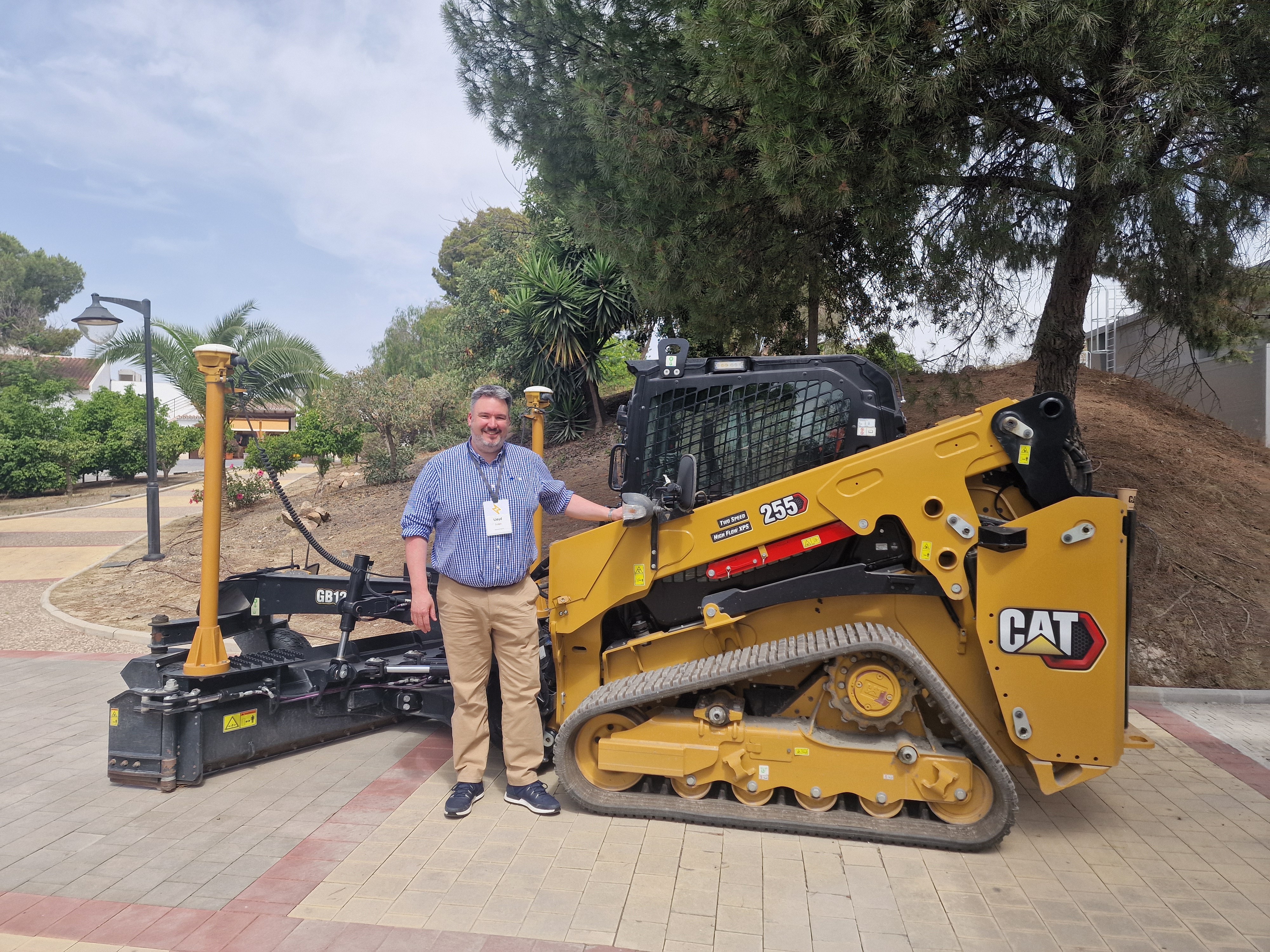 Lloyd standing in front of a Skid steer Loader