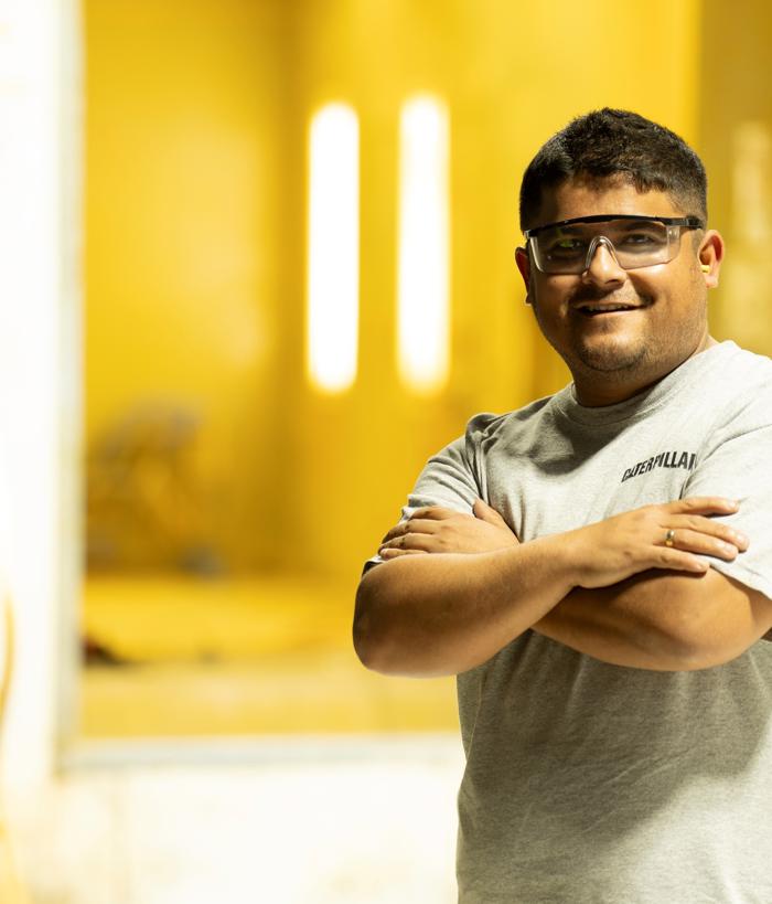 uma pessoa com óculos e uma camisa cinza com os braços cruzados