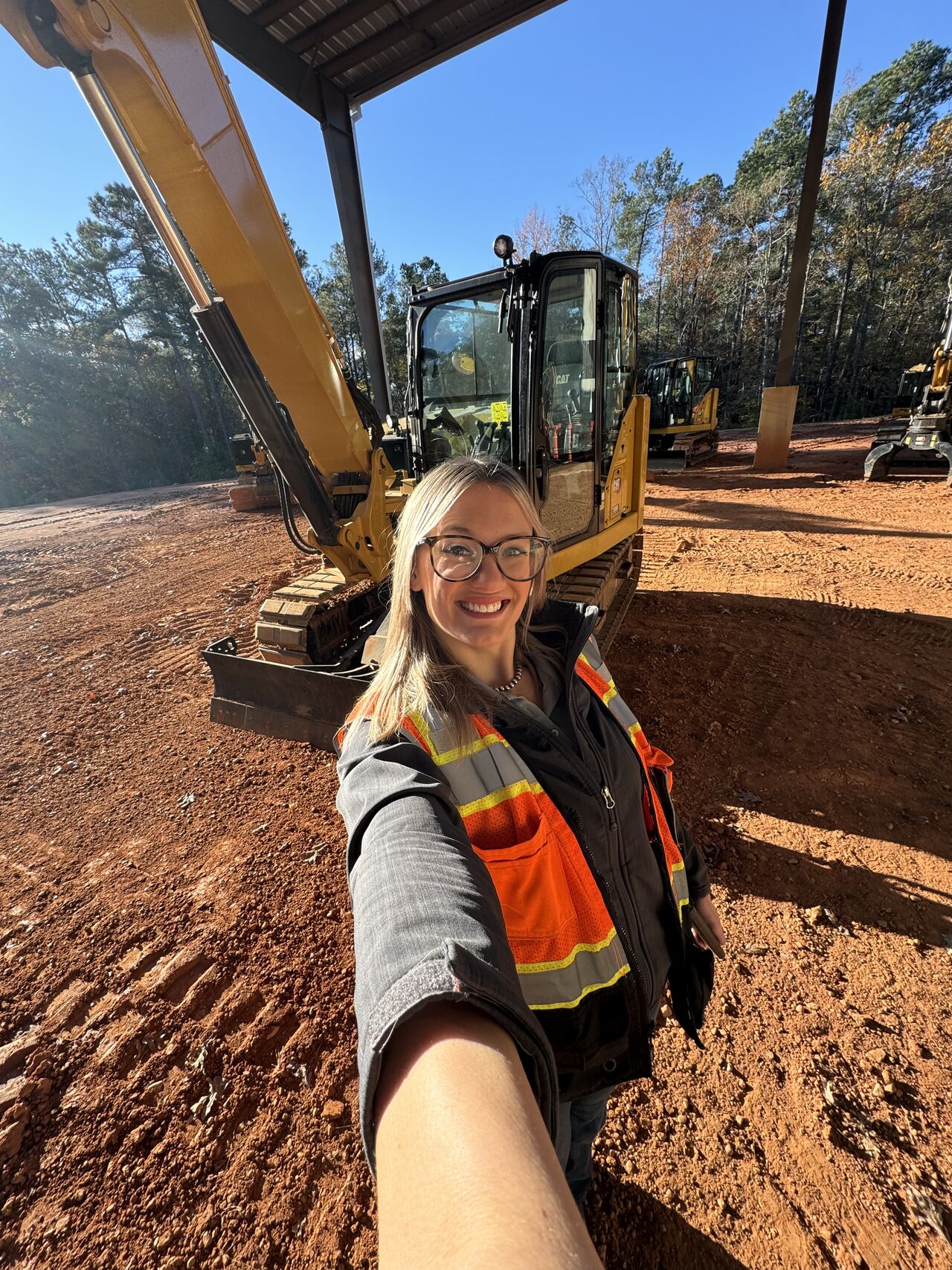 a person taking a selfie with a construction vehicle