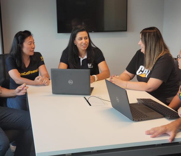 一群女人围坐在一张桌子旁,桌上放着笔记本电脑